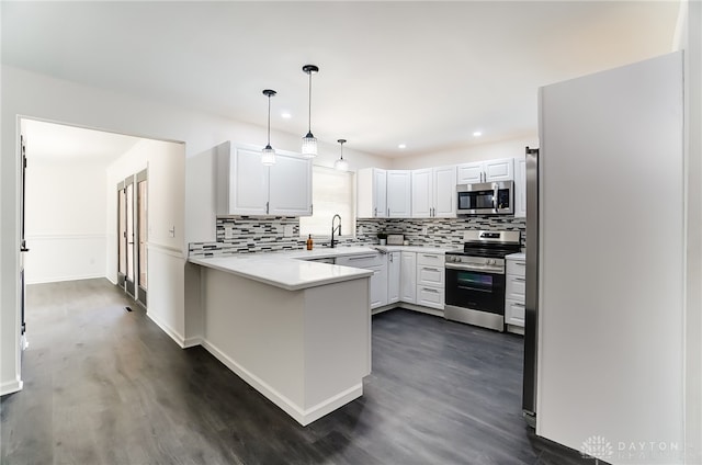 kitchen with white cabinetry, kitchen peninsula, stainless steel appliances, and dark hardwood / wood-style floors