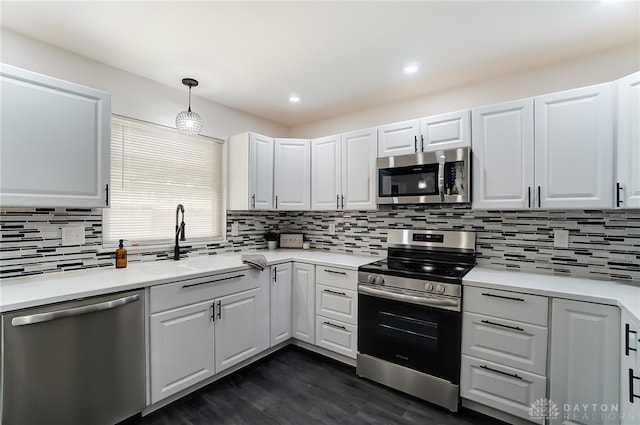 kitchen with dark hardwood / wood-style flooring, backsplash, stainless steel appliances, sink, and white cabinetry