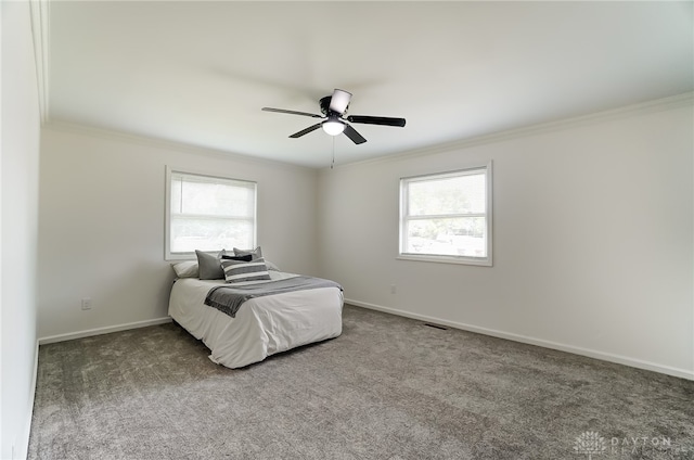 carpeted bedroom featuring crown molding, multiple windows, and ceiling fan