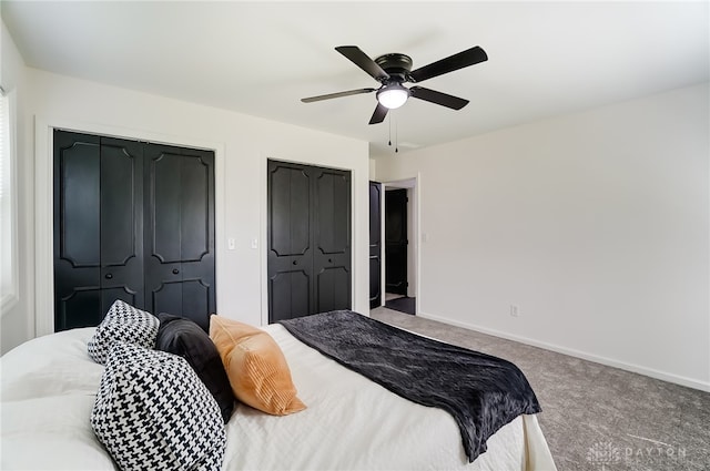 carpeted bedroom featuring multiple closets and ceiling fan