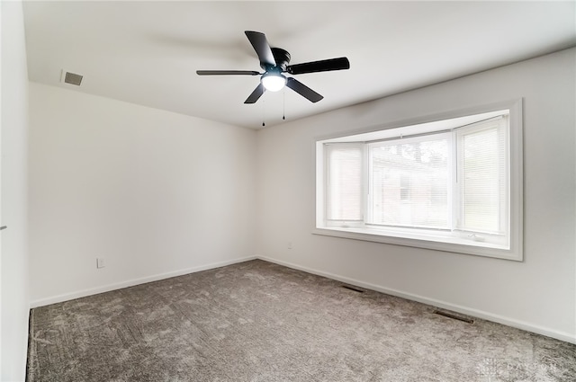 empty room featuring ceiling fan and carpet