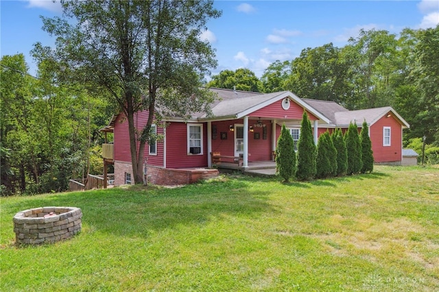 view of front facade featuring covered porch, a front lawn, and an outdoor fire pit