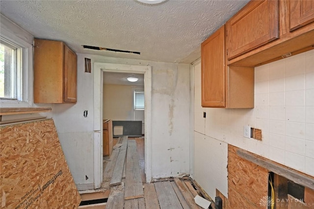 kitchen with light wood-type flooring and a textured ceiling