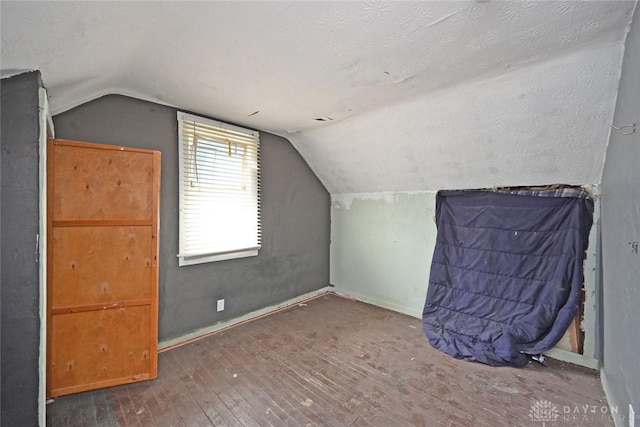 bonus room featuring vaulted ceiling and dark wood-type flooring