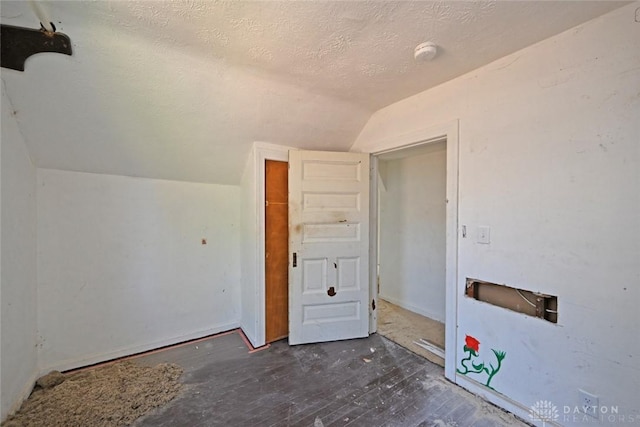 bonus room featuring a textured ceiling, dark wood-type flooring, and lofted ceiling