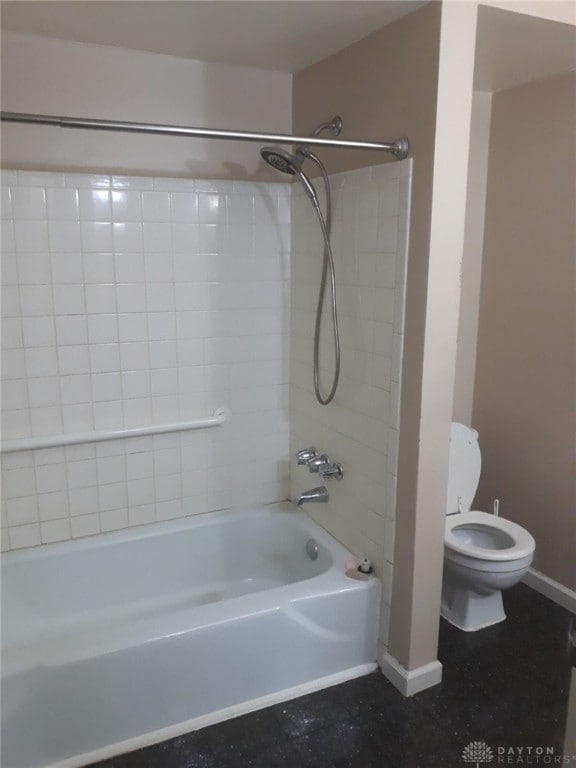 bathroom with tiled shower / bath combo and toilet