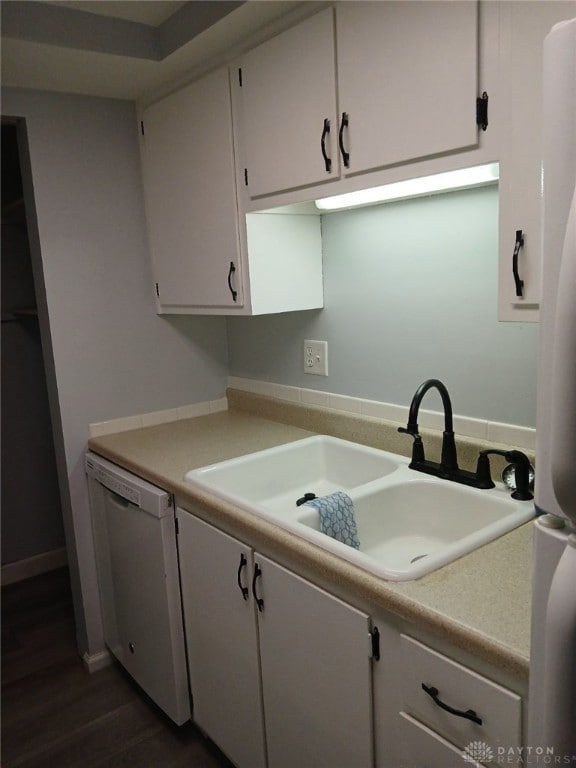 clothes washing area with sink and dark wood-type flooring