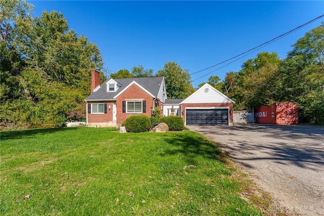 cape cod home featuring a garage and a front lawn