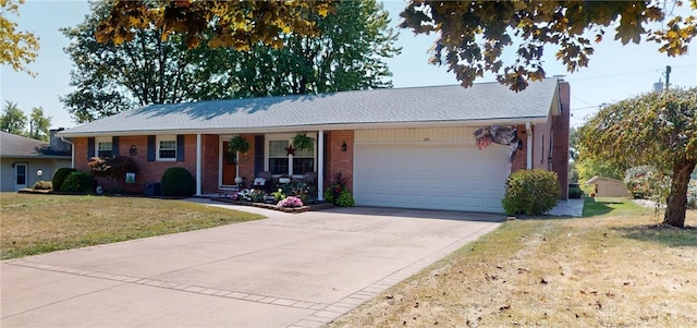 single story home featuring a front lawn, concrete driveway, brick siding, and a garage