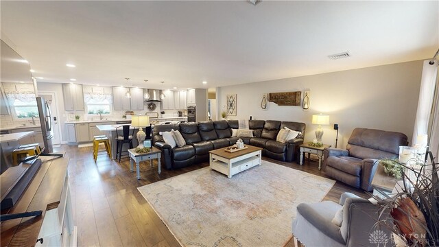 living room featuring sink and light hardwood / wood-style flooring