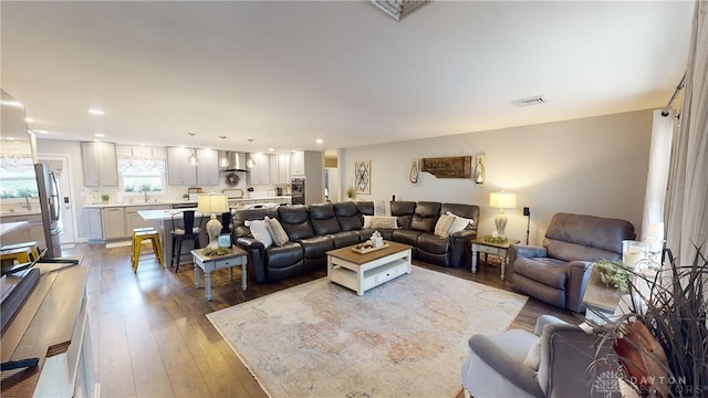 living area featuring recessed lighting, visible vents, and light wood-type flooring