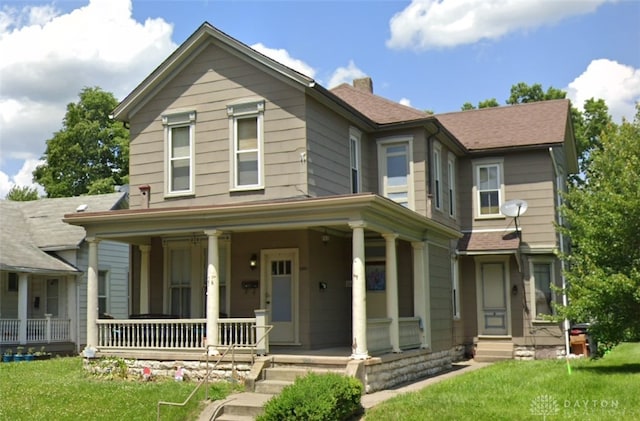 view of front facade with a front lawn and covered porch