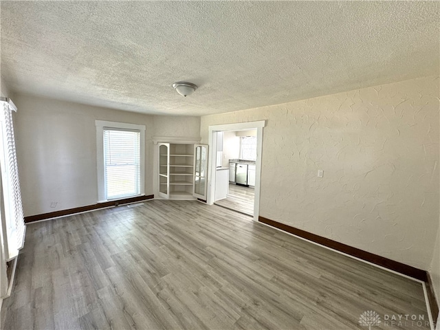 empty room with a textured ceiling and hardwood / wood-style floors