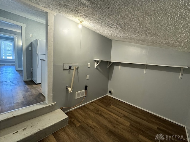 clothes washing area featuring washer hookup, a textured ceiling, and dark hardwood / wood-style flooring