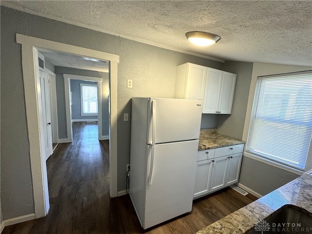 kitchen featuring white fridge, a textured ceiling, white cabinetry, dark hardwood / wood-style floors, and vaulted ceiling