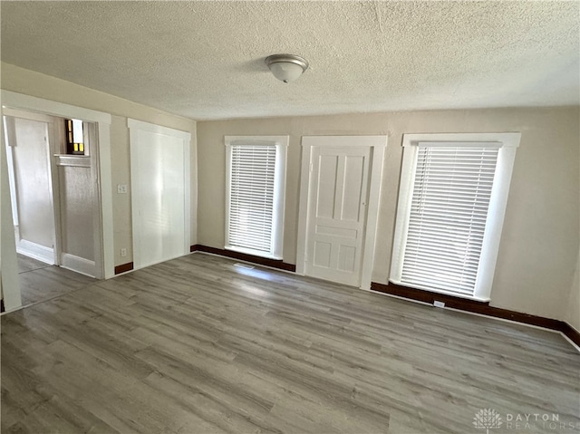 interior space featuring a textured ceiling and wood-type flooring