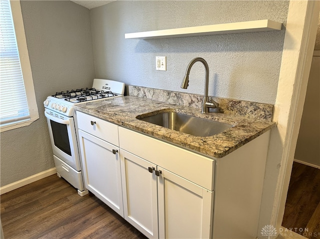 kitchen featuring white cabinets, sink, white range with gas stovetop, light stone countertops, and dark hardwood / wood-style flooring