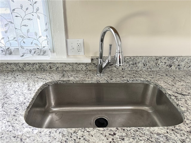 room details featuring sink and light stone counters