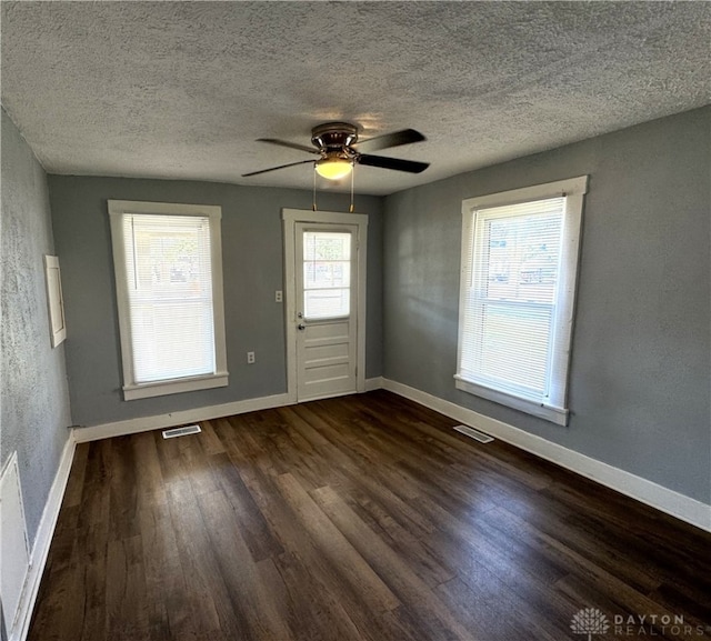 interior space featuring ceiling fan, a textured ceiling, and dark wood-type flooring