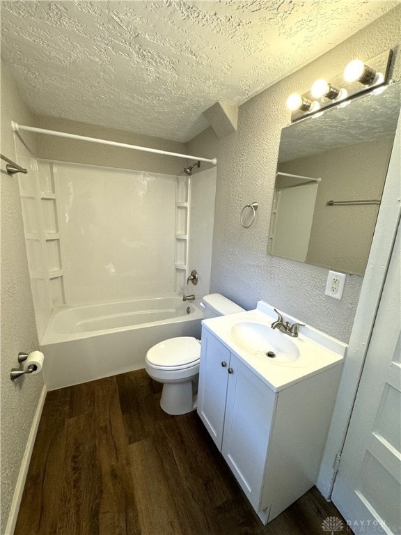 full bathroom with vanity, toilet, tub / shower combination, a textured ceiling, and hardwood / wood-style floors