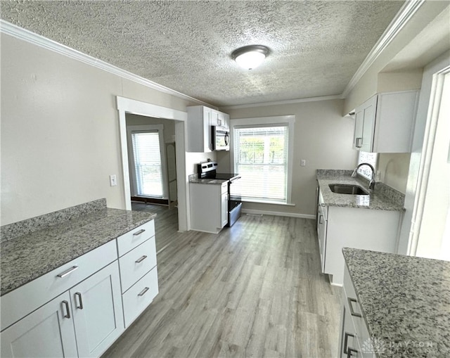 kitchen featuring white cabinets, appliances with stainless steel finishes, light wood-type flooring, and sink