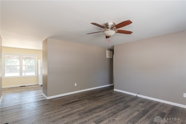 empty room with dark hardwood / wood-style flooring and ceiling fan