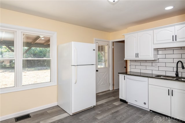 kitchen featuring backsplash, white appliances, sink, white cabinets, and hardwood / wood-style floors