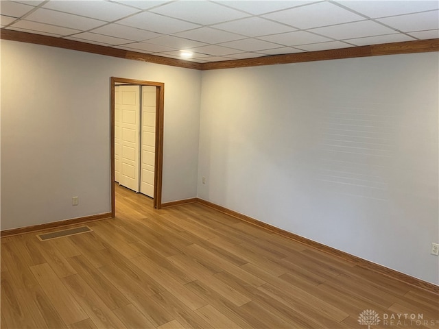 unfurnished room featuring light wood-type flooring and a paneled ceiling