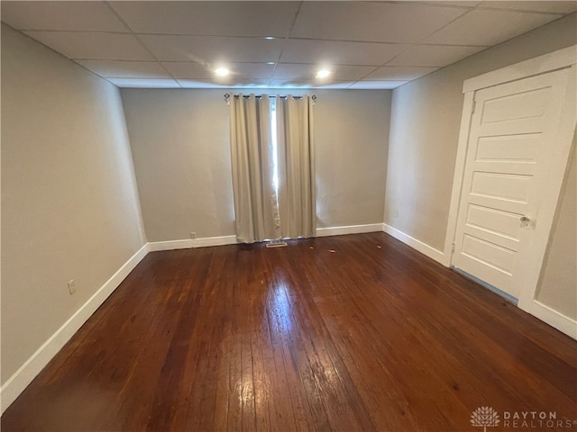 empty room featuring dark hardwood / wood-style flooring and a drop ceiling