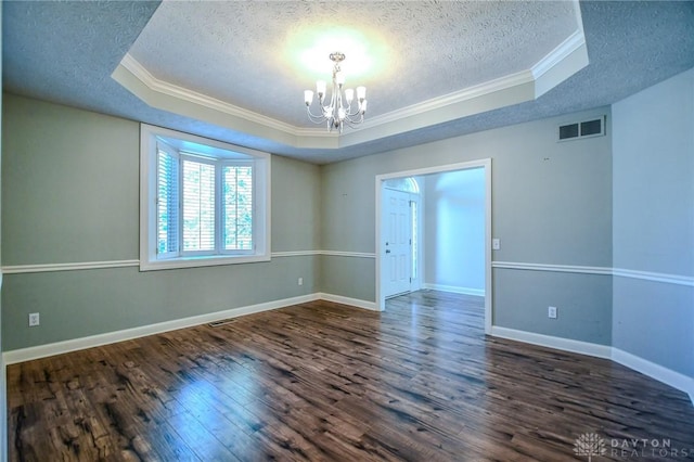 empty room with an inviting chandelier, a raised ceiling, dark hardwood / wood-style flooring, a textured ceiling, and crown molding