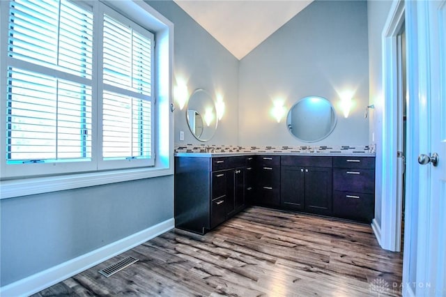 bathroom with lofted ceiling, vanity, and hardwood / wood-style floors