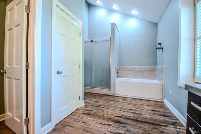 bathroom featuring wood-type flooring and separate shower and tub