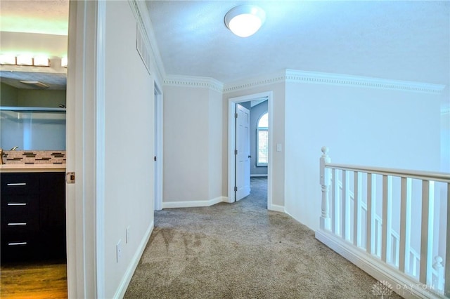 hall featuring carpet flooring and crown molding