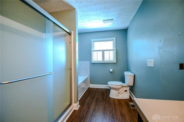 bathroom with a textured ceiling, toilet, hardwood / wood-style floors, and plus walk in shower