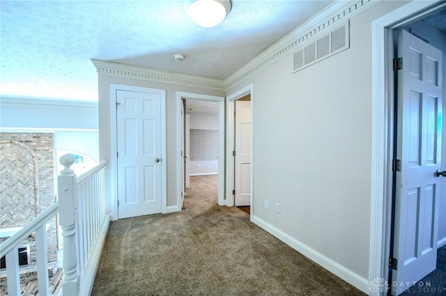 hallway with carpet floors, crown molding, and a textured ceiling