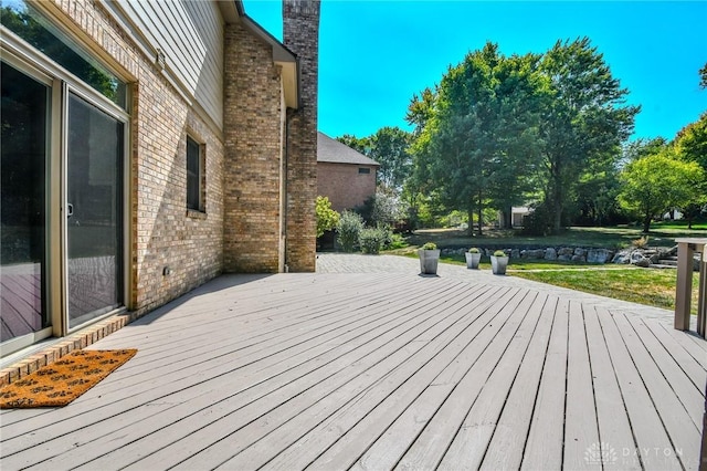 wooden terrace featuring a lawn