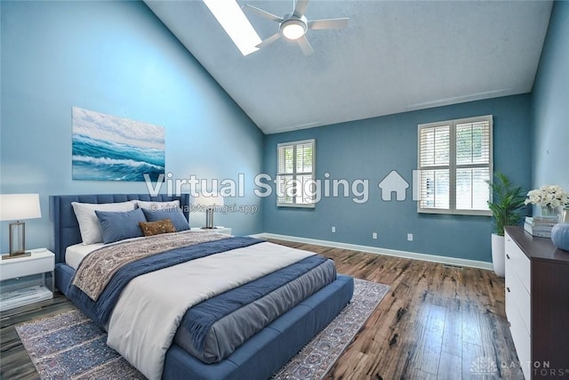 bedroom featuring ceiling fan, a skylight, hardwood / wood-style flooring, and multiple windows