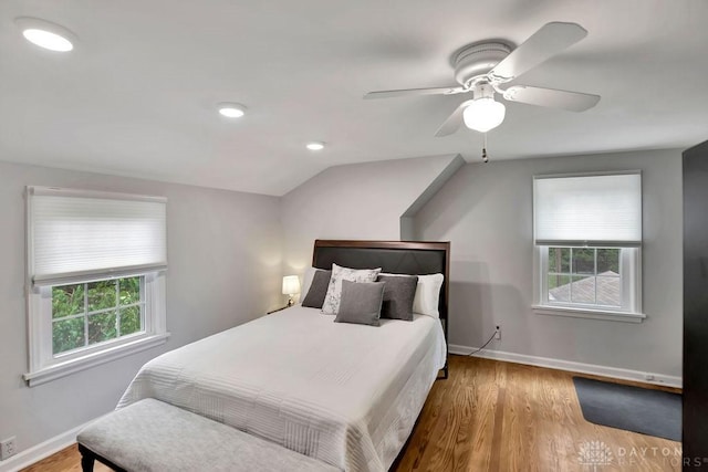 bedroom with hardwood / wood-style floors, vaulted ceiling, and ceiling fan