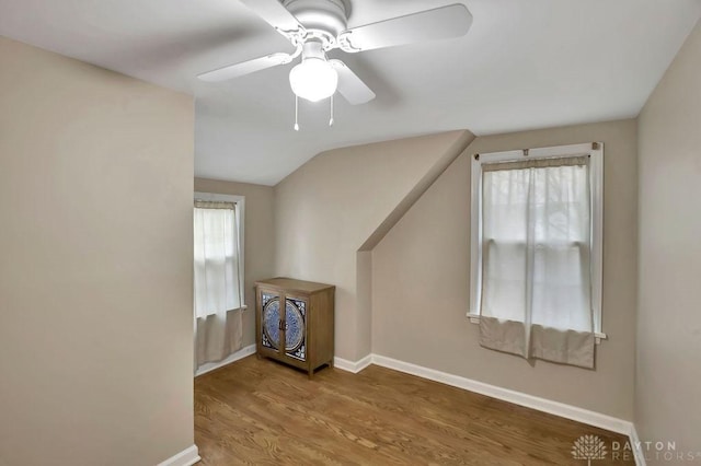 additional living space with ceiling fan, wood-type flooring, and vaulted ceiling