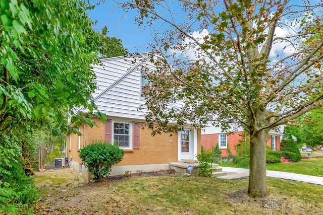 view of front of house featuring a front lawn and central air condition unit