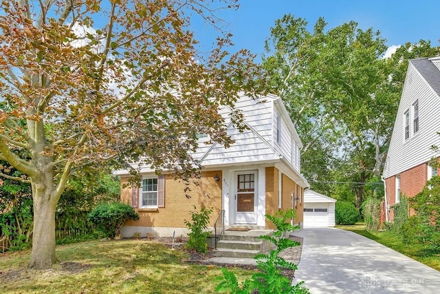 view of front of house with a garage, an outbuilding, and a front lawn