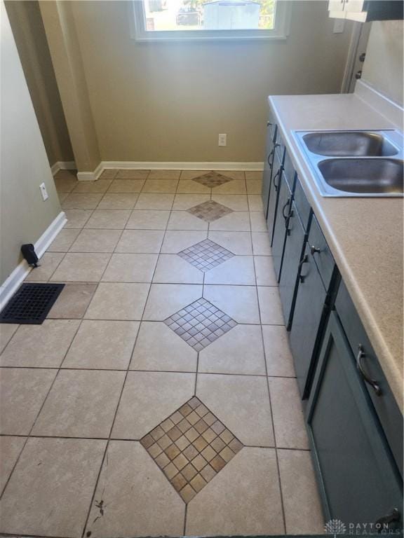 kitchen with light tile patterned flooring, a healthy amount of sunlight, sink, and gray cabinetry