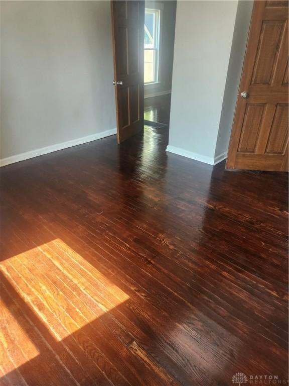 unfurnished room featuring dark hardwood / wood-style flooring