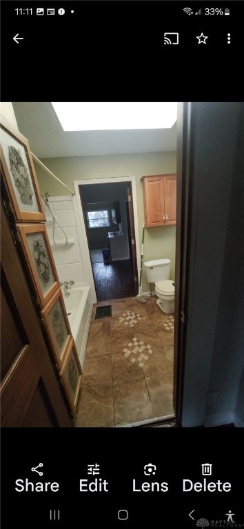 bathroom with shower / bathtub combination and toilet