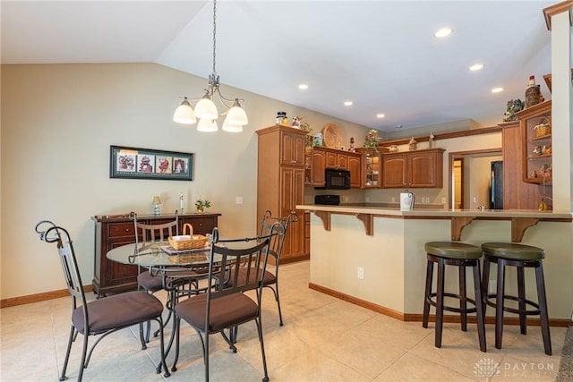 kitchen with lofted ceiling, a breakfast bar, a notable chandelier, and kitchen peninsula