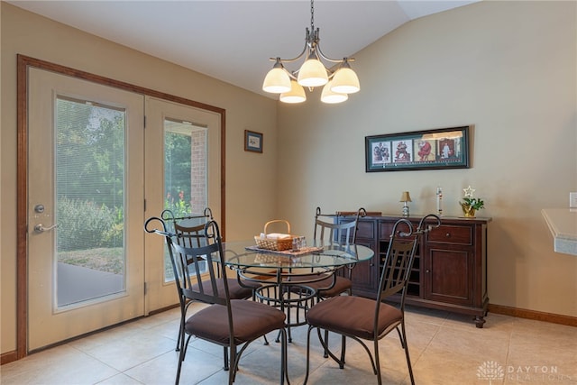 dining space with lofted ceiling, light tile patterned floors, and a notable chandelier