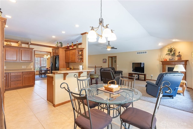 tiled dining space featuring lofted ceiling and ceiling fan with notable chandelier