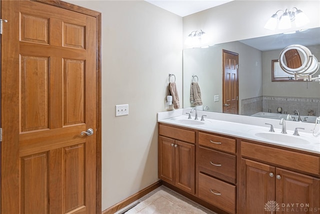 bathroom with tile patterned floors, a bath, and vanity