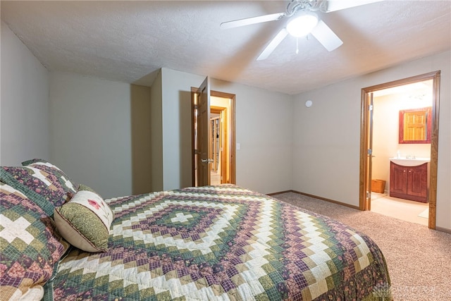 carpeted bedroom featuring ceiling fan, connected bathroom, and a textured ceiling