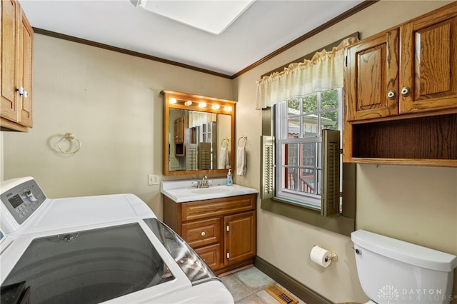 bathroom featuring washing machine and clothes dryer, tile patterned flooring, toilet, vanity, and ornamental molding